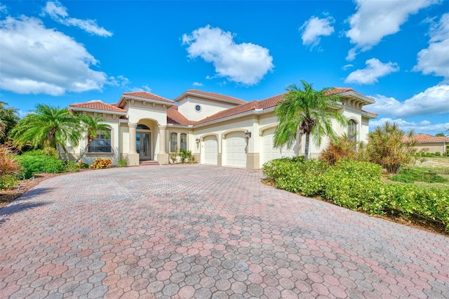 1509 Raphis Royale Blvd, Englewood, FL 34223 - mediterranean / spanish home featuring an attached garage, decorative driveway, stucco siding, and a tile roof