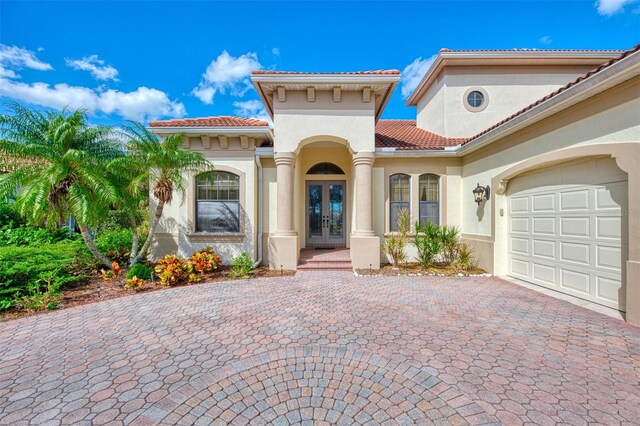 1509 Raphis Royale Blvd, Englewood, FL 34223 - view of exterior entry with french doors, decorative driveway, stucco siding, and a tiled roof