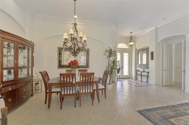 dining space with ornamental molding, a notable chandelier, and light tile patterned floors