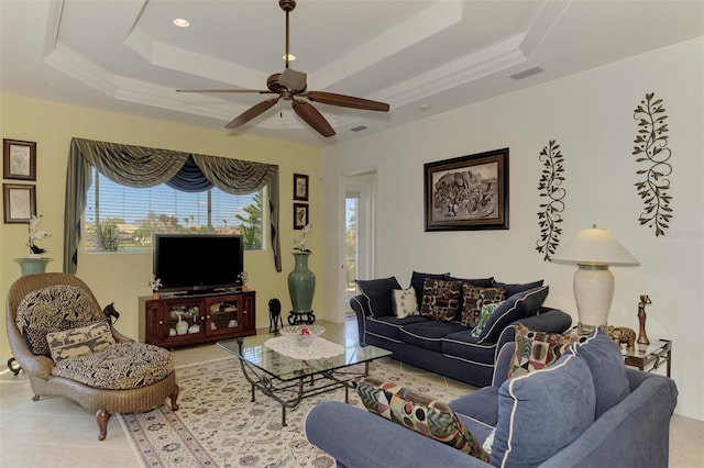 living room with a tray ceiling, light tile patterned floors, and ceiling fan