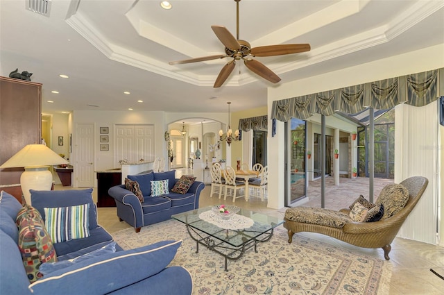 living room featuring ceiling fan with notable chandelier, a raised ceiling, and ornamental molding