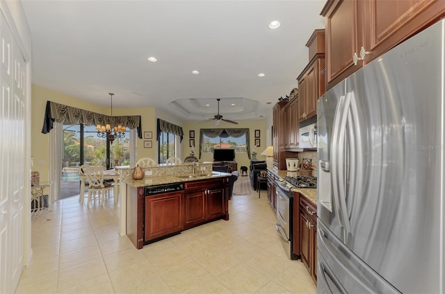 kitchen with stainless steel appliances, a raised ceiling, light stone countertops, hanging light fixtures, and ceiling fan with notable chandelier