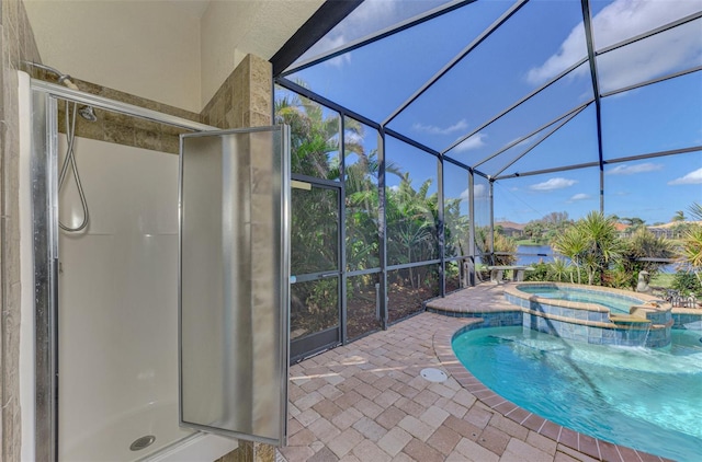 view of pool with glass enclosure, a patio, and an in ground hot tub