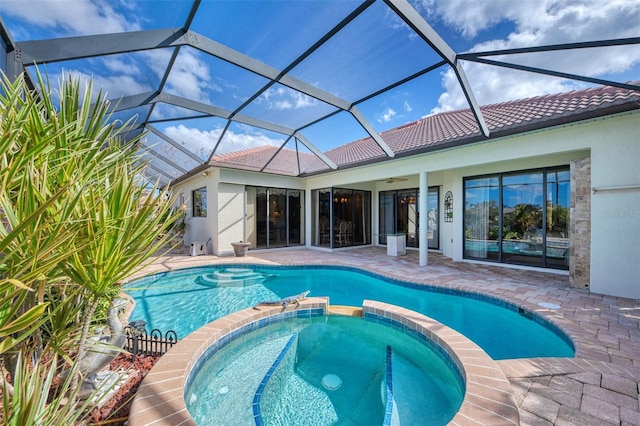 view of pool with ceiling fan, glass enclosure, an in ground hot tub, and a patio area