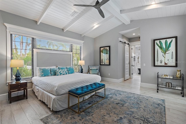 bedroom featuring ceiling fan, a barn door, connected bathroom, and multiple windows