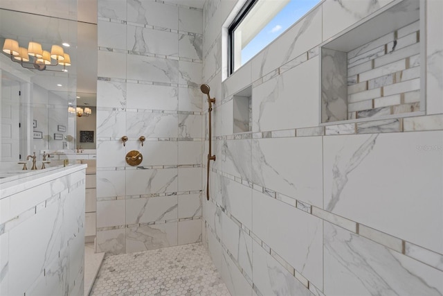 bathroom featuring vanity, an inviting chandelier, and tiled shower