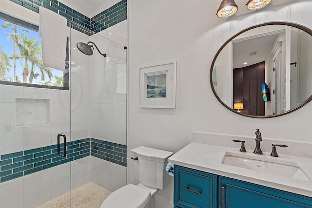 bathroom featuring an enclosed shower, vanity, and toilet