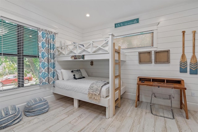 bedroom featuring wood-type flooring and wooden walls