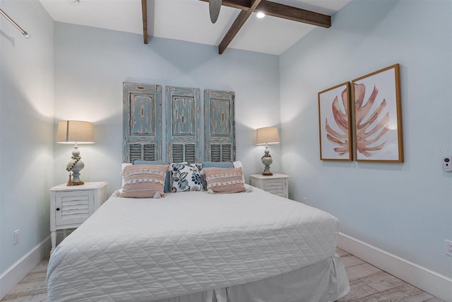 bedroom with ceiling fan, light hardwood / wood-style flooring, and beamed ceiling