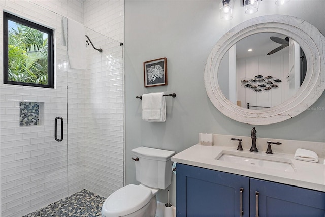 bathroom with a shower with shower door, toilet, and vanity