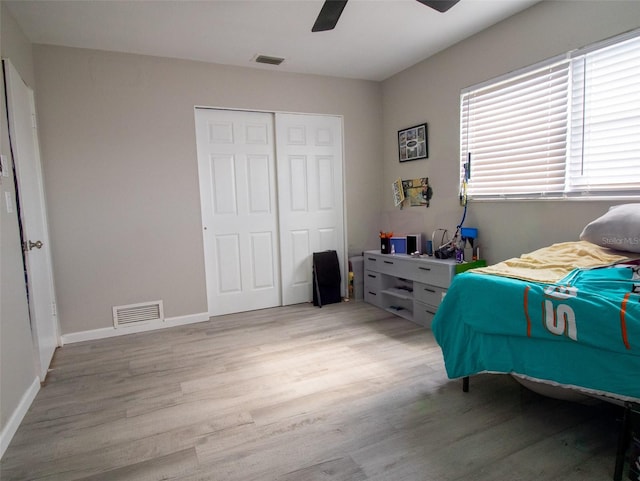 bedroom featuring light hardwood / wood-style floors, ceiling fan, and a closet