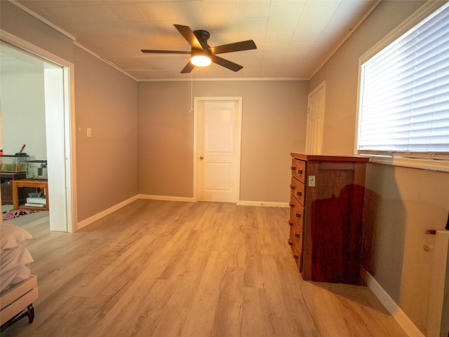 spare room featuring light wood-type flooring, ceiling fan, and crown molding