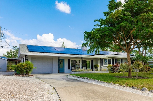 ranch-style home featuring a garage and solar panels