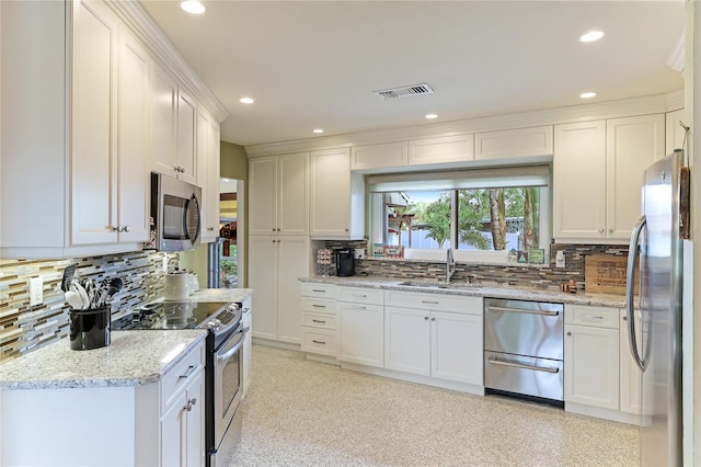 kitchen featuring tasteful backsplash, white cabinetry, and stainless steel appliances