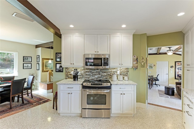 kitchen featuring white cabinetry, decorative backsplash, appliances with stainless steel finishes, and ceiling fan