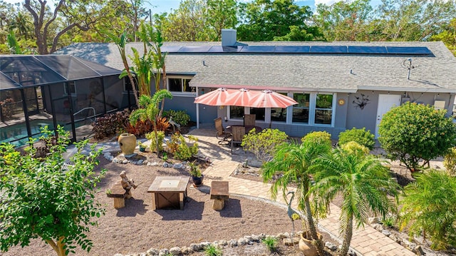 back of property with glass enclosure and a patio area