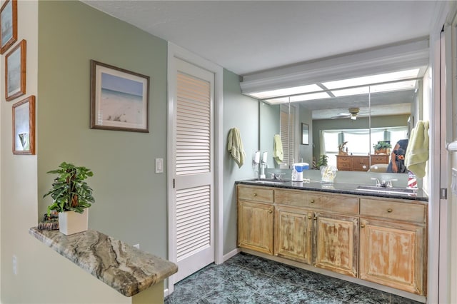 bathroom with ceiling fan and vanity