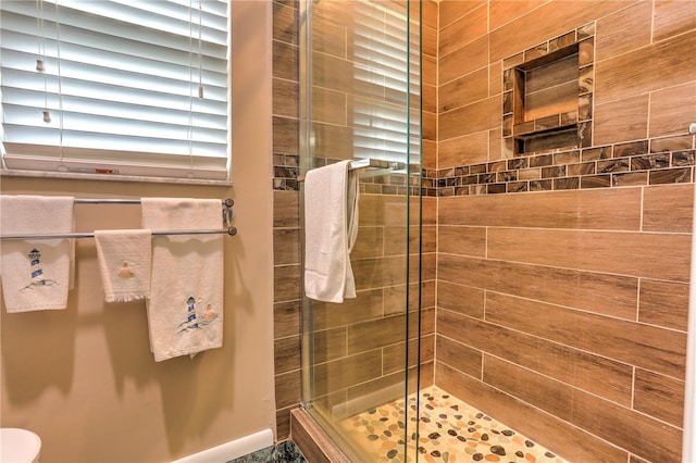 bathroom featuring a shower with door