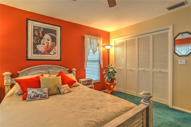 bedroom featuring ceiling fan, dark colored carpet, a closet, and a textured ceiling