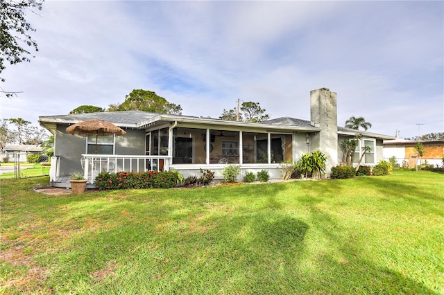 back of property featuring a sunroom and a yard