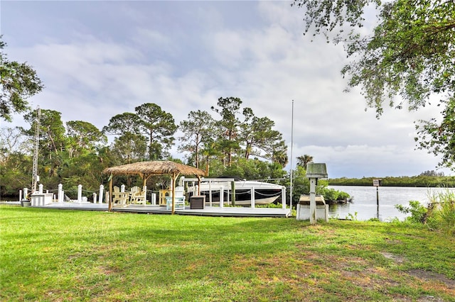 surrounding community featuring a water view, a lawn, and a boat dock