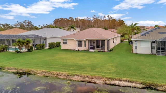 back of property featuring glass enclosure, a water view, a lawn, and a sunroom