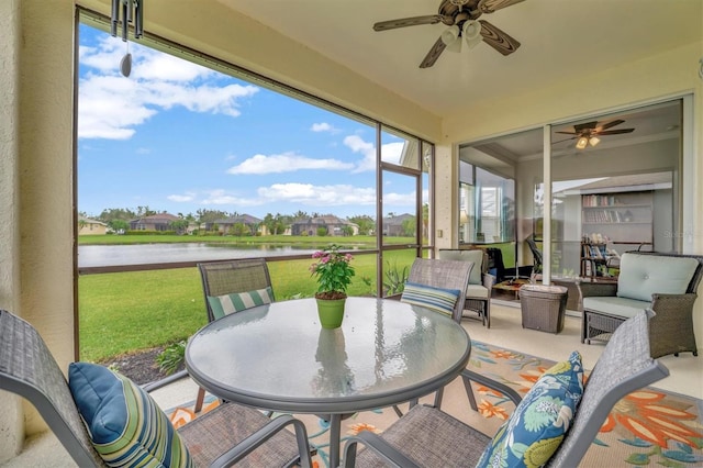 sunroom / solarium with a water view and ceiling fan