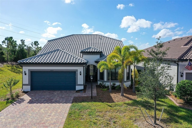 mediterranean / spanish home with a garage and a front lawn