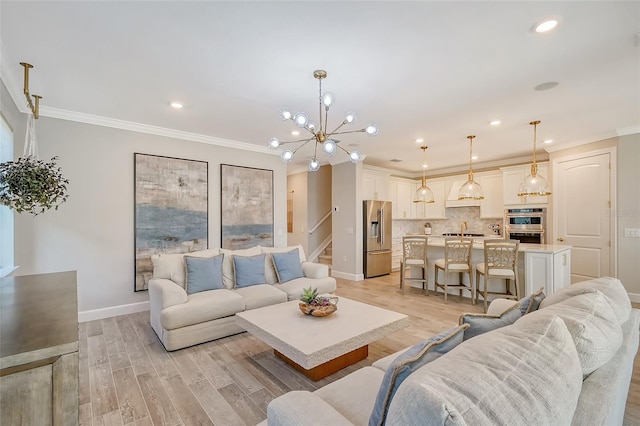 living room with ornamental molding, a notable chandelier, and light wood-type flooring