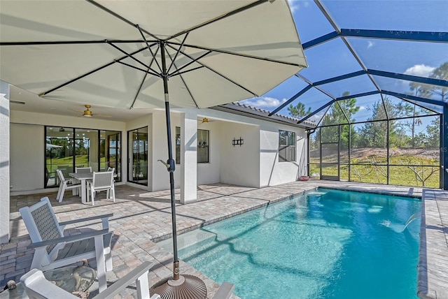 view of pool featuring a patio area, pool water feature, ceiling fan, and glass enclosure