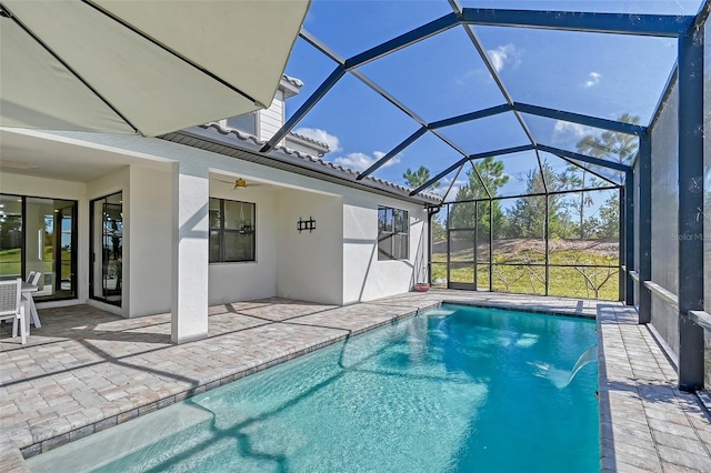 view of swimming pool featuring a lanai, a patio area, pool water feature, and ceiling fan