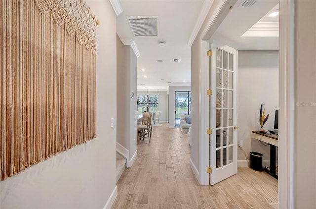 corridor featuring crown molding and light hardwood / wood-style floors