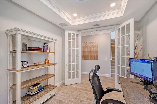 office space with crown molding, light wood-type flooring, a raised ceiling, and french doors