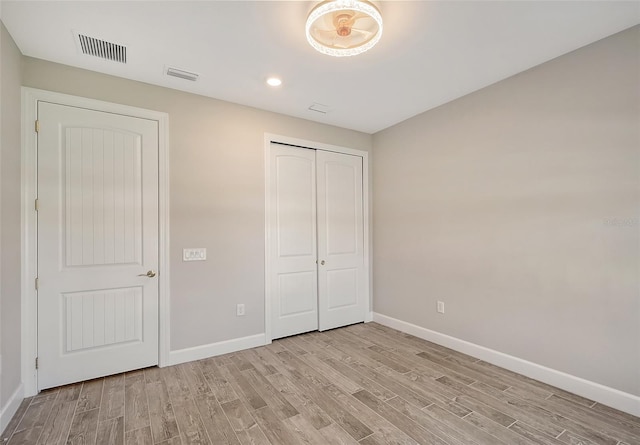 unfurnished bedroom featuring a closet and light hardwood / wood-style flooring