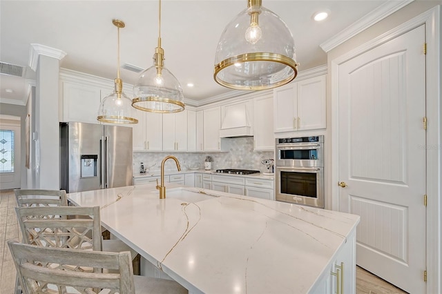 kitchen with pendant lighting, white cabinetry, stainless steel appliances, and sink