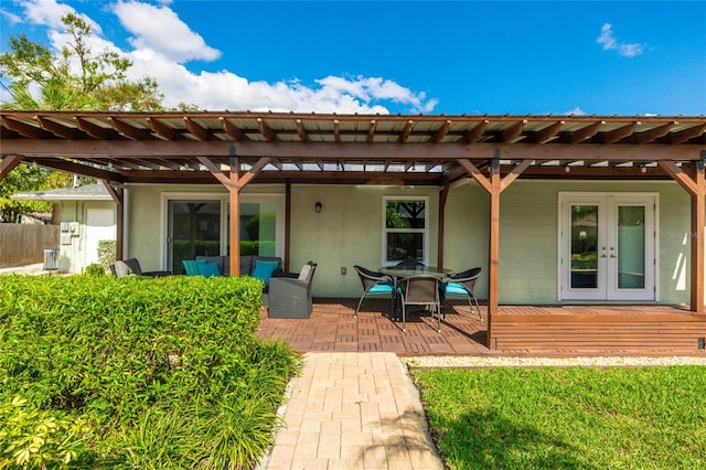 back of property featuring a pergola and french doors