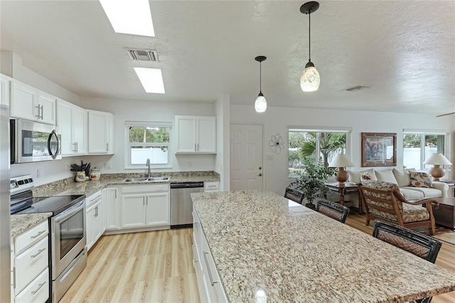 kitchen with light hardwood / wood-style flooring, sink, a healthy amount of sunlight, and stainless steel appliances