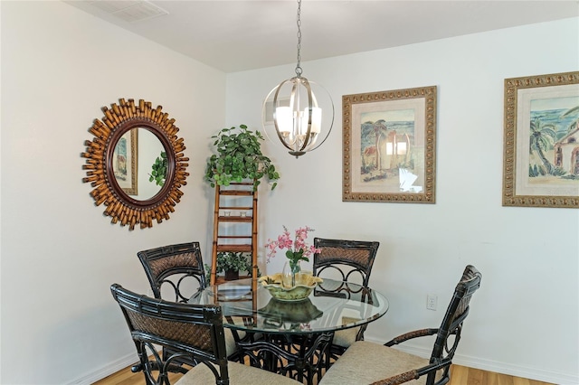 dining space with hardwood / wood-style floors and a chandelier