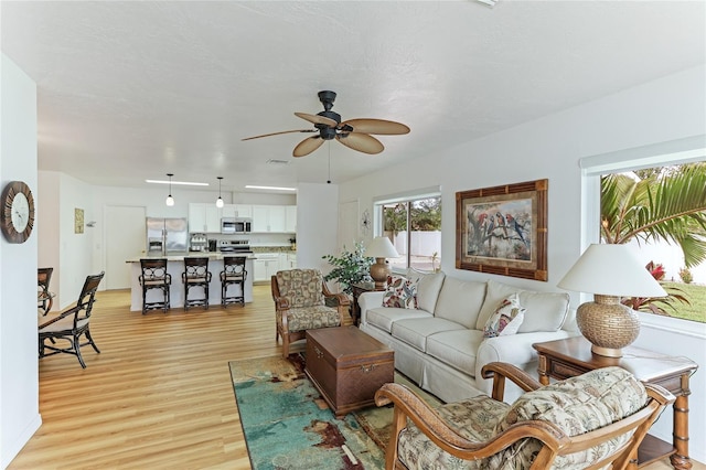 living room featuring ceiling fan and light hardwood / wood-style floors