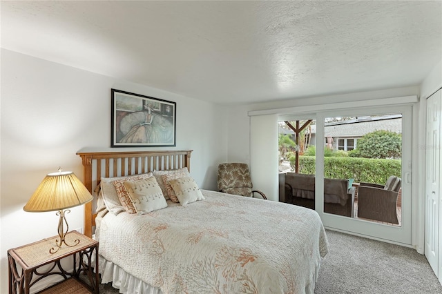 carpeted bedroom featuring access to exterior, a textured ceiling, and a closet