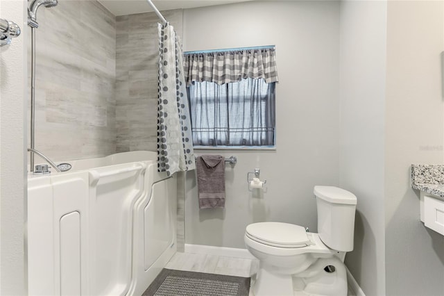 bathroom featuring curtained shower, vanity, and toilet