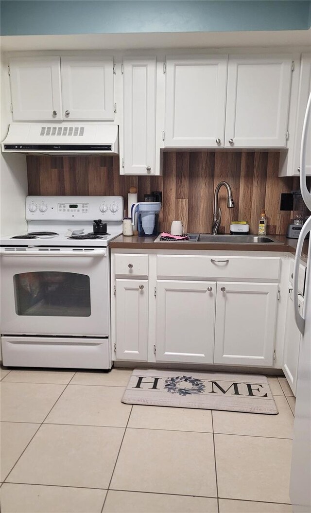 kitchen with white electric range oven, white cabinetry, light tile patterned floors, and exhaust hood