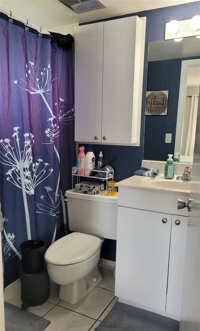 bathroom featuring vanity, tile patterned flooring, and toilet