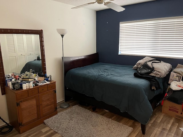 bedroom with light wood-type flooring, a textured ceiling, and ceiling fan