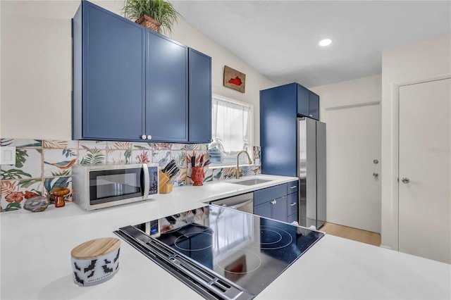 kitchen with light hardwood / wood-style floors, sink, appliances with stainless steel finishes, blue cabinets, and decorative backsplash