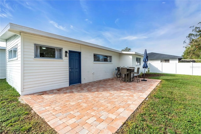 rear view of property featuring a patio area and a yard