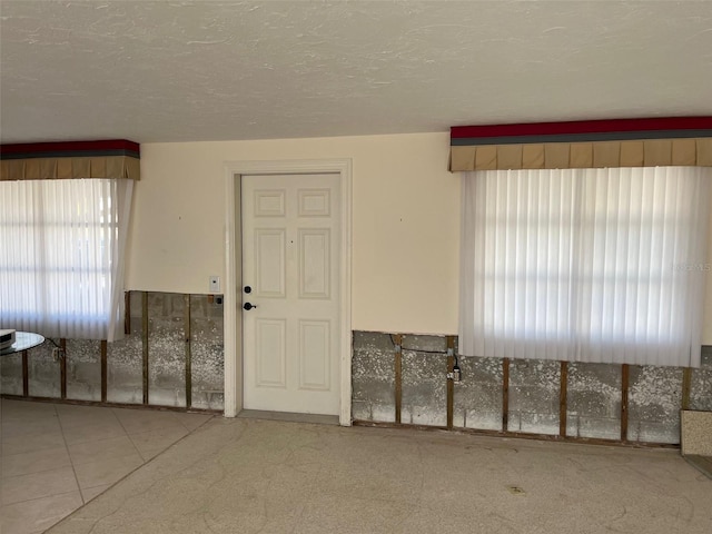 tiled spare room with a healthy amount of sunlight and a textured ceiling