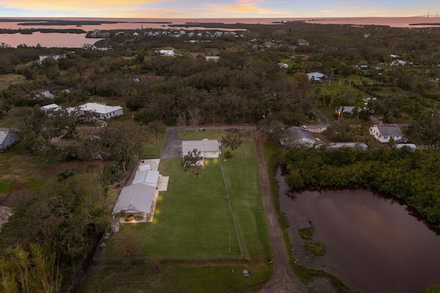 aerial view at dusk featuring a water view