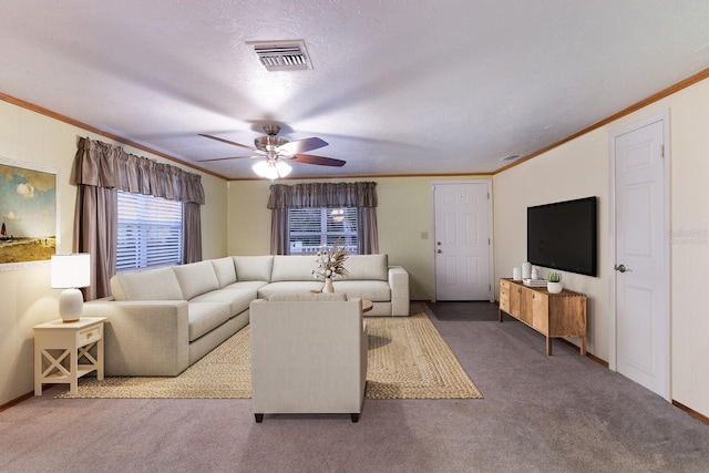 living area with ceiling fan, visible vents, carpet floors, and ornamental molding