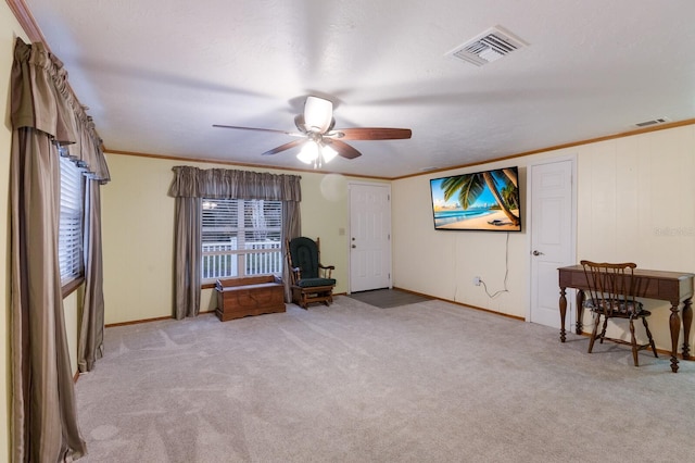 interior space with a textured ceiling, light carpet, ceiling fan, and crown molding